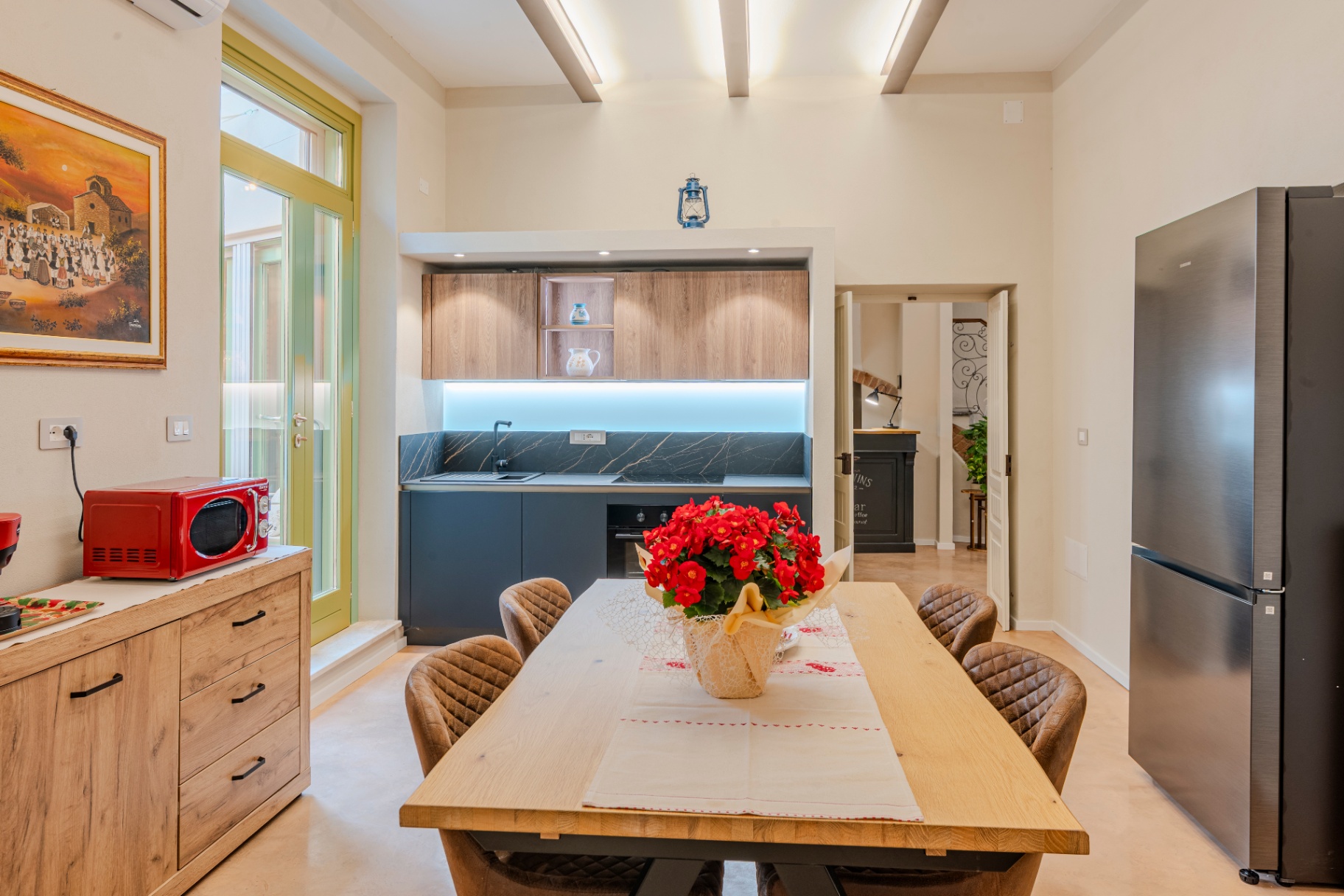 Cucina comune con porta verde sul cortile
